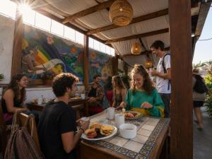 a group of people sitting at a table eating food at Yellow House Hostel B&B in Antigua Guatemala