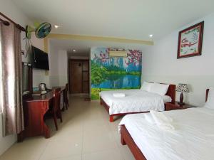a hotel room with two beds and a painting on the wall at Hai Yen Family Hotel in Mui Ne