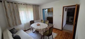 a living room with a table and a couch at Zlata Apartment in Fužine