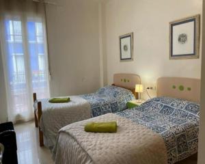 a bedroom with two beds and a window at KAIROS HOME y Garaje , Algemesí Home in Algemesí +10 photos