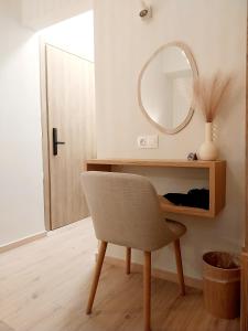 a mirror and a chair in a room with a table at Lithos in Palaiochora