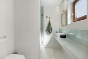 a white bathroom with a toilet and a sink at Casa Miclá in Lagos +17 photos