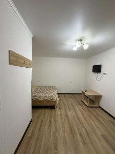 a room with a bed and a table in it at Moonlight in Cholpon-Ata