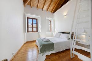 a bedroom with a white bed and a ladder at Casa Miclá in Lagos