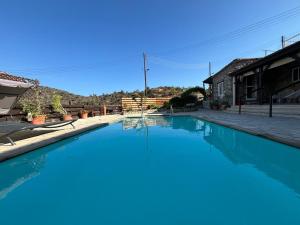 a large blue swimming pool next to a house at Kassandra's Cottage in Vasa