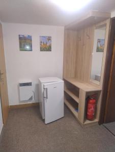 a small kitchen with a refrigerator and a shelf at Ubytování U Jindřicha ll in Weissbach
