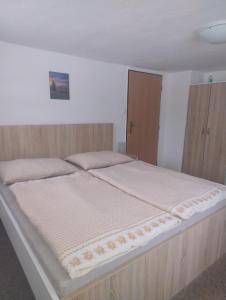 a bedroom with a large bed with a wooden frame at Ubytování U Jindřicha ll in Weissbach