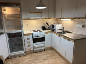 a small kitchen with a stove and a sink at Cozy Apartment with Private Sauna in Vaasa