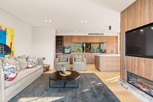 a living room with a couch and a tv at Casa Celeste, Grand Architectural Residence in Wollongong