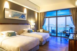 a hotel room with two beds and a large window at Forest City Marina Hotel in Nusajaya +61 photos
