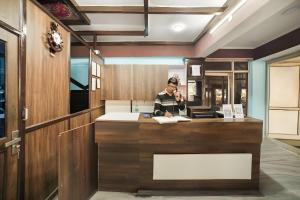 a man talking on a cell phone at a counter at Hotel Konark INN in Bareilly