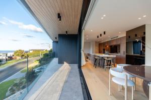 an open kitchen and dining room with a view of the ocean at Casa Celeste, Grand Architectural Residence in Wollongong +29 photos