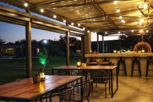 a patio with tables and a bar with lights at Symponia Guesthouse in Khanzi