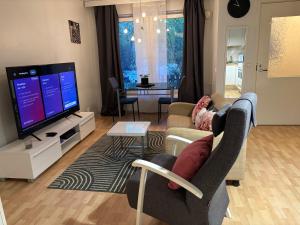 a living room with a couch and a tv at Cozy Apartment with Private Sauna in Vaasa +7 photos