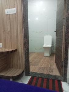 a bathroom with a toilet and a shower with a door at Hotel Shankar Place in Khātu +18 photos