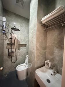 a bathroom with a white toilet and a sink at Manatad Transient Deluxe Room 2 in Surigao +8 photos