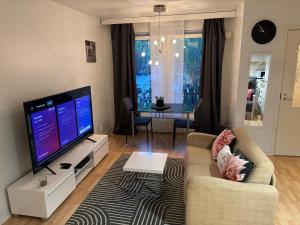 a living room with a tv and a couch and a table at Cozy Apartment with Private Sauna in Vaasa