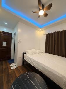 a bedroom with a ceiling fan and a bed at Manatad Transient Deluxe Room 2 in Surigao