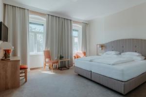a bedroom with a large bed and a television at Inselhotel Faakersee in Faak am See +148 photos