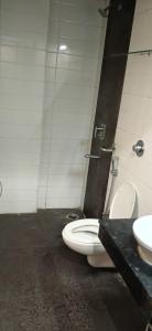 a bathroom with a toilet and a sink at Hotel Midtown in Rourkela