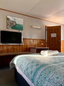 a bedroom with a large bed and a flat screen tv at Holbrook Motor Village in Holbrook