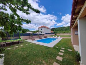 Blick auf den Hinterhof eines Hauses mit Swimmingpool in der Unterkunft Villa Hirundinidae in Gornji Muć