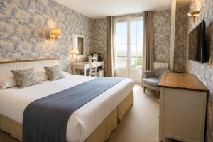 a hotel room with a bed and a desk and a window at Hôtel Villa Flornoy Pornichet Baie de la Baule in Pornichet