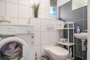 a bathroom with a washing machine and a sink at Bungalows im Grünen in Lychen