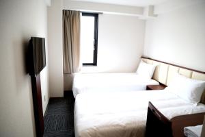 a hotel room with two beds and a television at Asia Hotel Narita in Narita