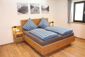 a bedroom with a bed with blue and white pillows at Ferienwohnung Stuibock in Fischen