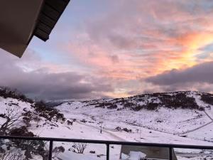 a view of a snow covered mountain with a sunset at Illabunda Ski Lodge in Perisher Valley
