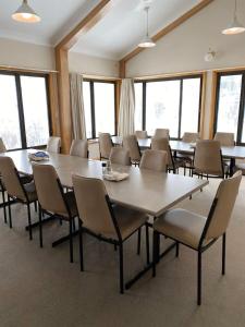 a conference room with tables and chairs and windows at Illabunda Ski Lodge in Perisher Valley