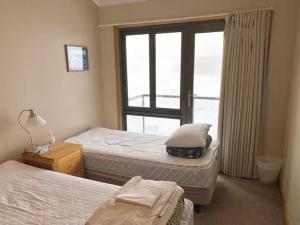 a bedroom with two beds and a window at Illabunda Ski Lodge in Perisher Valley +2 photos