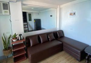 a brown couch in a living room with a mirror at Cliff Cabanas by Hiverooms in Catmon