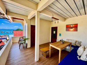 a living room with a table and a view of the ocean at De Nata in Labuan Bajo