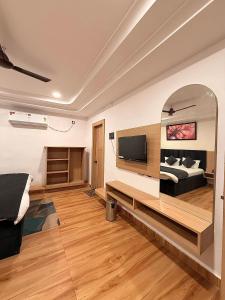 a bedroom with a bed and a tv on a wall at Hotel The Edge in Rewa