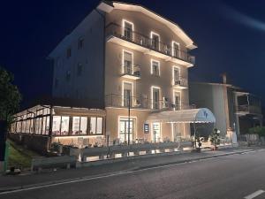 a large white building with an umbrella in front of it at Terme Palace Hotel in Montecatini Terme