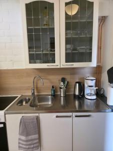 a kitchen with white cabinets and a sink at Kotoisa 2 in Seinäjoki