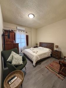 a bedroom with a bed and a couch and a chair at Akrotiri B&B in Porto Kagio