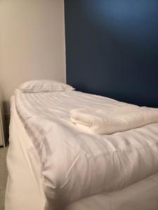 a white towel laying on top of a bed at Kotoisa 2 in Seinäjoki