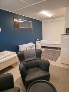 a room with a chair and a room with beds at Kotoisa 2 in Seinäjoki