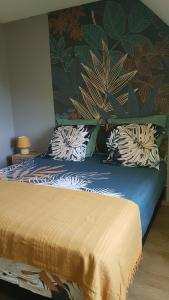 a bed with pillows on it in a bedroom at Floralie parking privé navette vers Aéroport ou Gare Beauvais in Saint-Paul