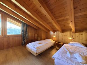 a bedroom with two beds in a wooden cabin at Mont Bijou MOUNTAIN & QUIET chalet 10 pers by Alpvision Résidences in Veysonnaz