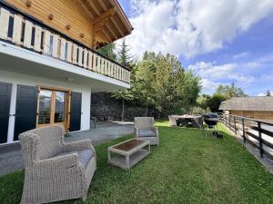 a yard with two chairs and a table and a patio at Mont Bijou MOUNTAIN & QUIET chalet 10 pers by Alpvision Résidences in Veysonnaz