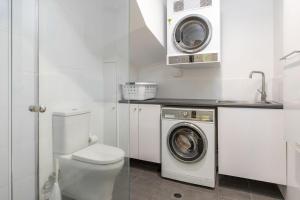 a white bathroom with a washing machine and a washer at Sandpiper 21 in Smiths Lake