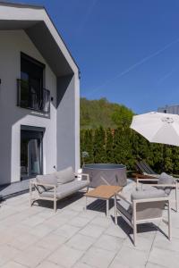 a patio with a table and chairs and an umbrella at Villa Alba Rekavice Krupa na Vrbasu in Banja Luka