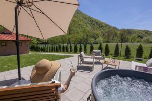 a person sitting in a chair with a hot tub at Villa Alba Rekavice Krupa na Vrbasu in Banja Luka