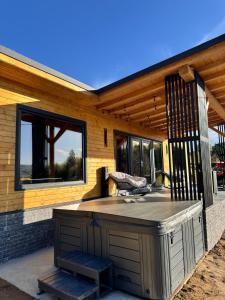 a building with a deck with a hot tub at Pitoresc Cabin in Tranisu