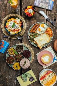 a table with plates of breakfast food on it at Drop Inn Hostels in Colombo