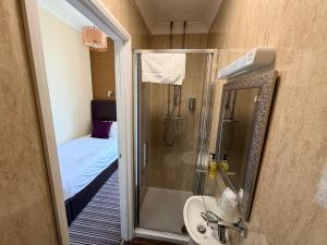 a bathroom with a shower and a sink and a toilet at Imperial Lodge in Great Yarmouth
